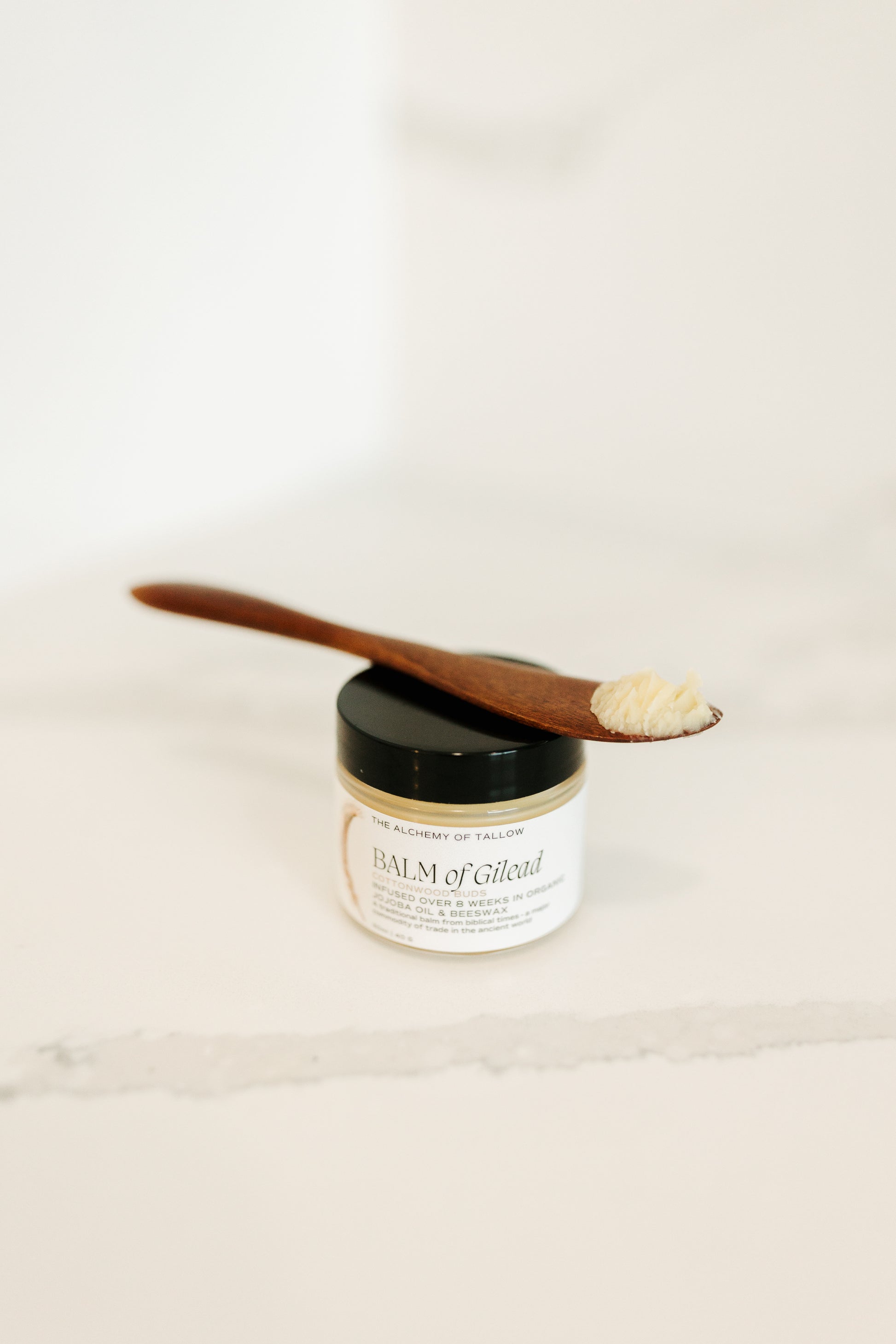 Jar of 'Balm of Gilead' with a wooden applicator on a white background