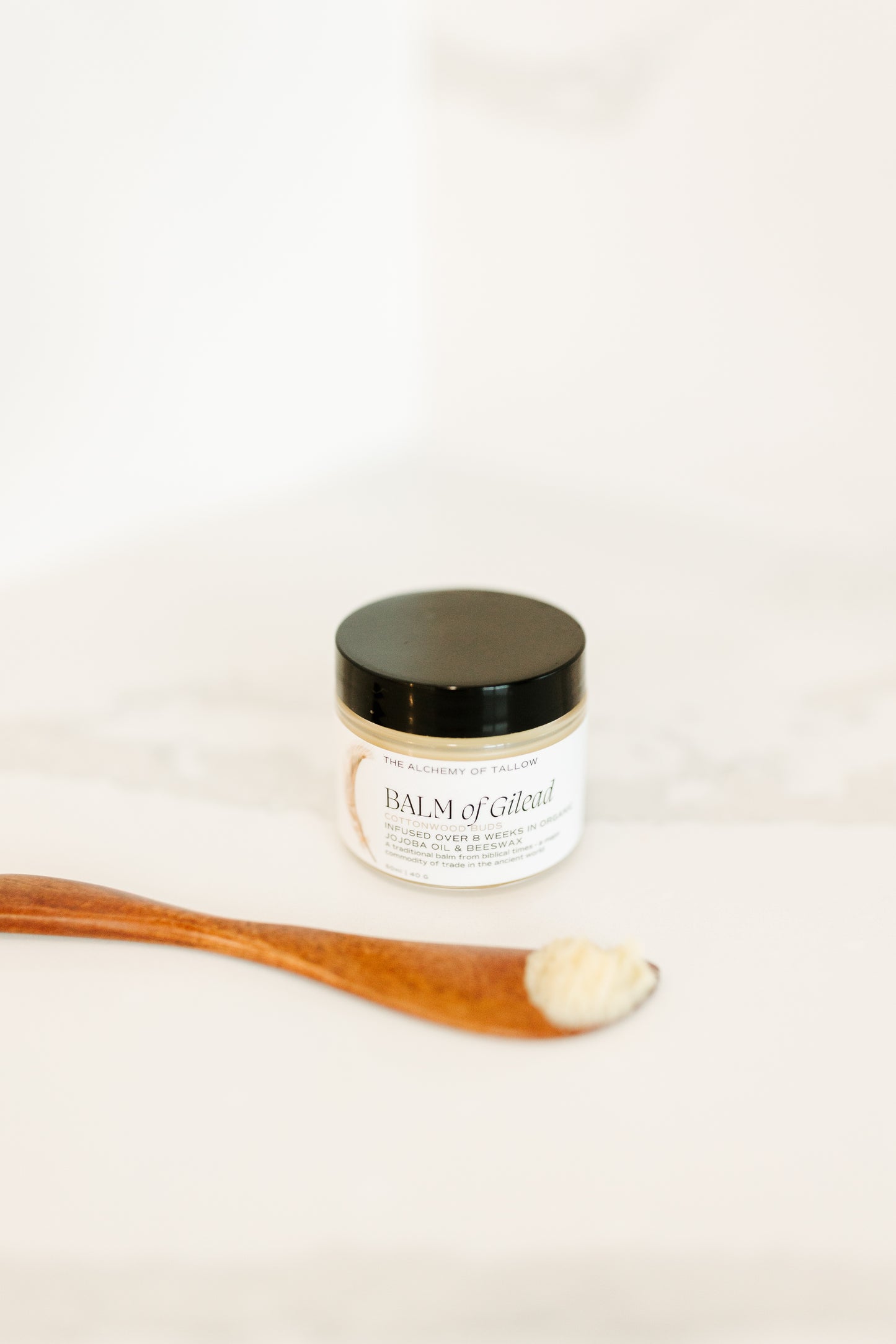 Jar of Balm of Gilead with wooden applicator on a white background