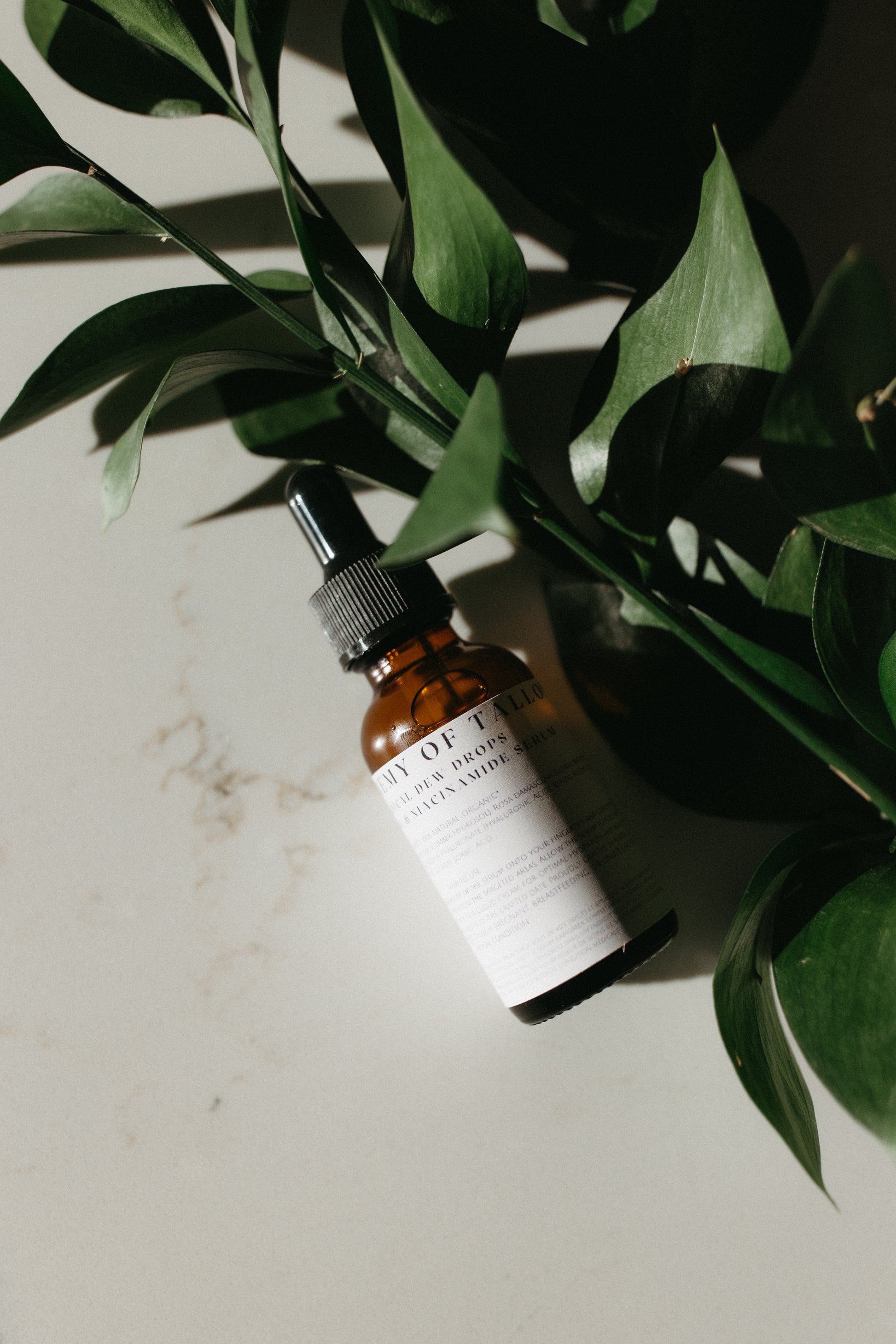 30ml bottle of Botanical Dew Drops serum, displayed alongside botanical elements, highlighting its hydrating formula with niacinamide and hyaluronic acid, designed to refine skin texture and provide deep hydration for a radiant complexion.